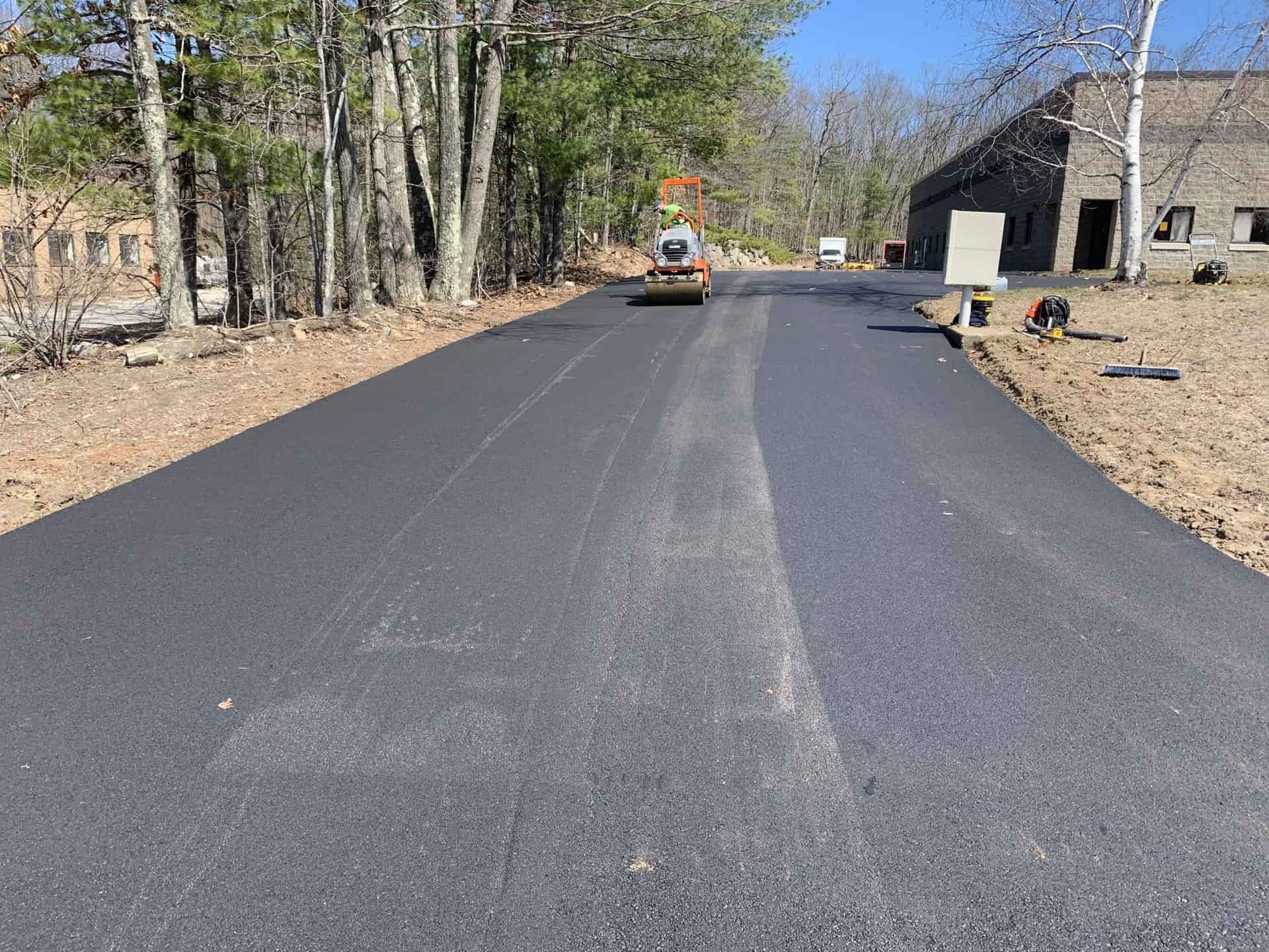 Commercial road paving through a wooded property